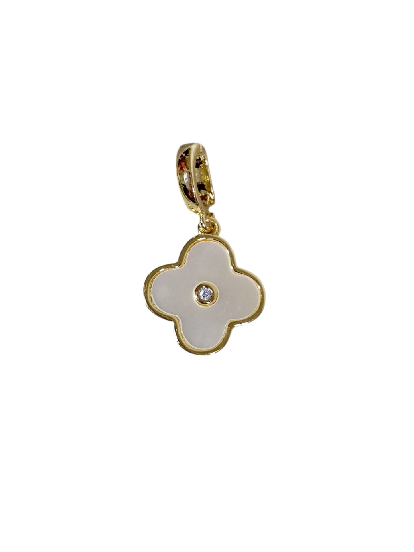 Gold pendant with a white enameled clover design on a marble surface
