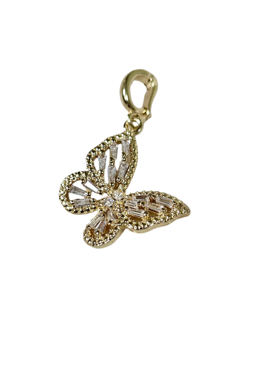 Gold butterfly-shaped pendant with diamonds on a marble surface