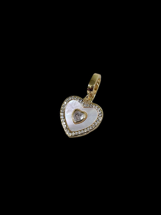 Heart-shaped pendant with a diamond on a marble surface
