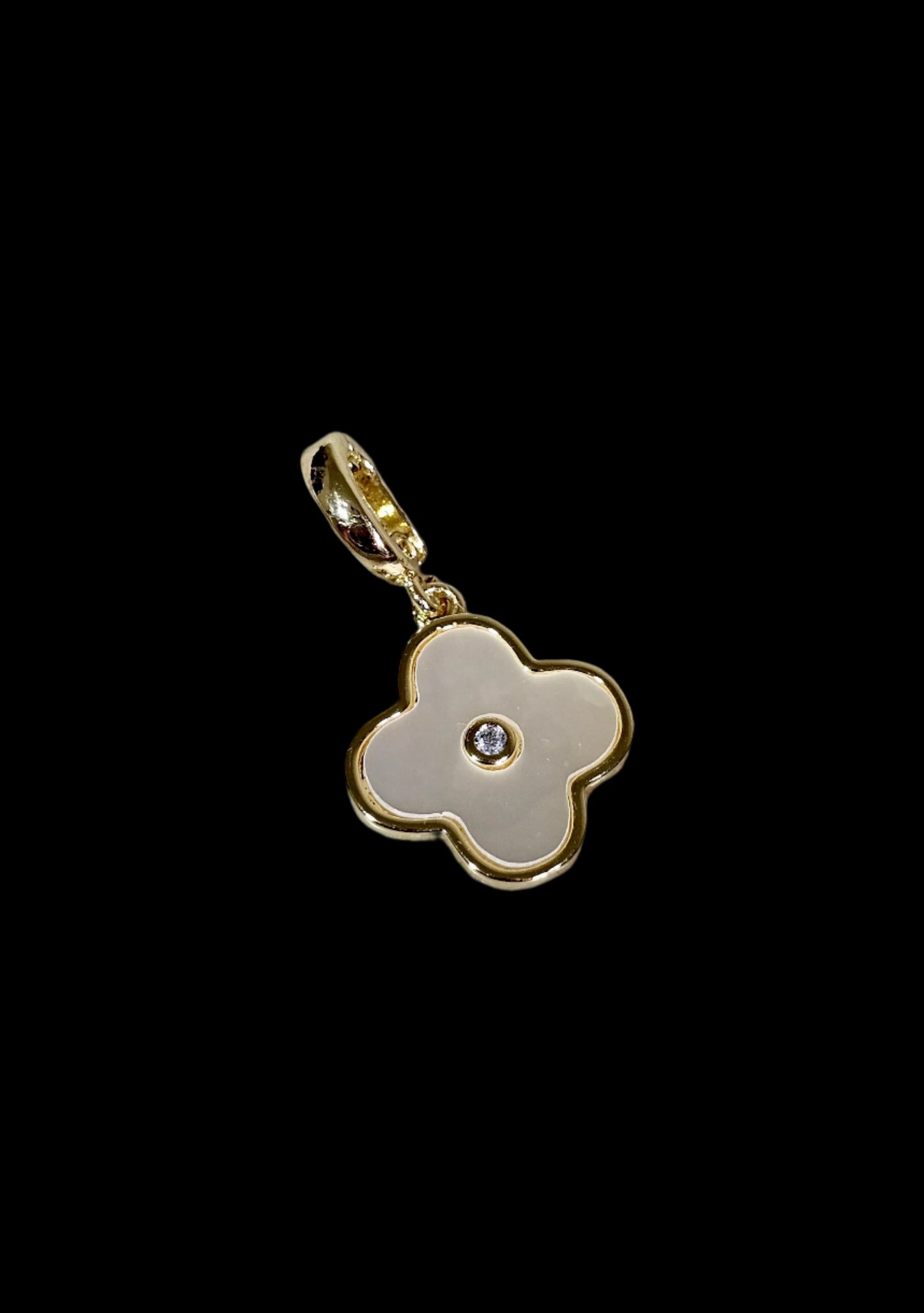 Gold flower-shaped pendant with a central gemstone on a marble surface